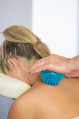 Close up of physiotherapist massaging female patient with blue m
