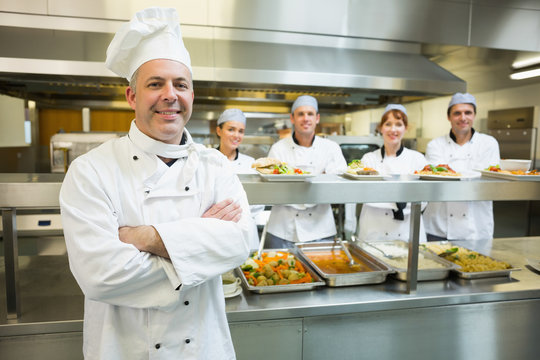 Proud Mature Head Chef Posing In A Modern Kitchen