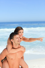 Man having wife a piggyback on the beach