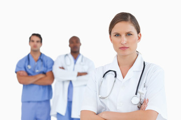 Fototapeta premium Female doctor with folded arms and male colleagues behind her