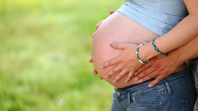 Couple with hands on baby belly of pregnant woman