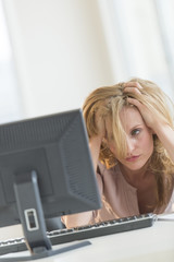 Frustrated Businesswoman Looking At Computer In Office