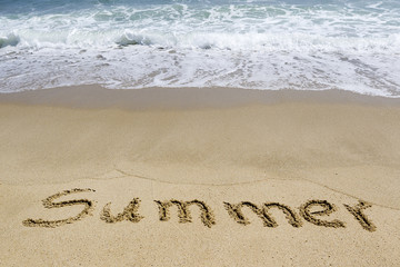 Word summer written in sand on the beach