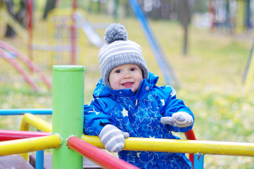 Fototapeta na wymiar happy smiling baby outdoors in autumn on playground