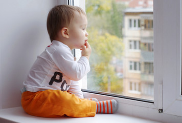 baby age of 1 year looks out of window