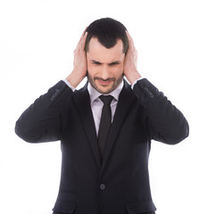 Annoyed businessman covering his ears with his hands