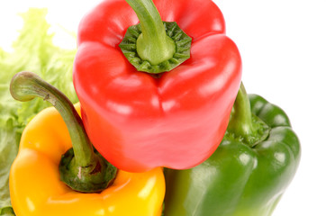 Red Green and Yellow peppers on salad leaf isolated on white bac
