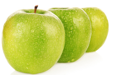 The ripe green apples covered by water drops.