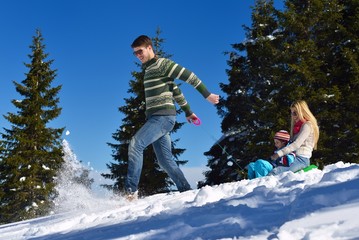 Naklejka na ściany i meble family having fun on fresh snow at winter