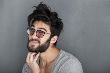sexy man rubbing his beard against wall