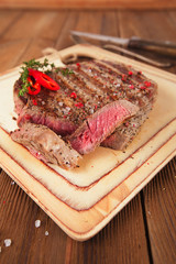 Beef steak on a wooden board and table