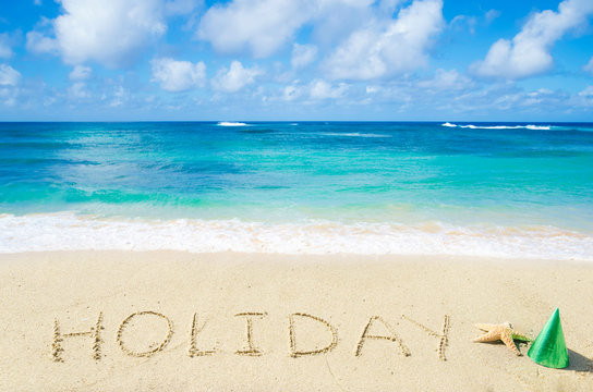Sign "Holiday" on the sandy beach