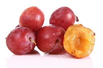 Plums on white background - one cut in half