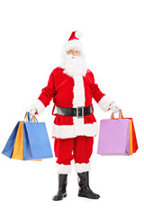 Full length portrait of a Santa Claus holding shopping bags