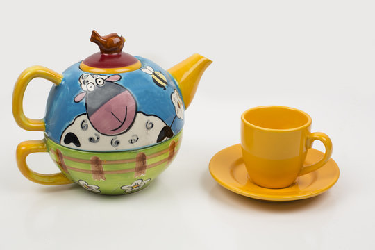Taza de t&eacute; y tetera de cer&aacute;mica decorada con motivos infantiles