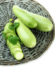 Sliced and whole raw zucchini, isolated on white