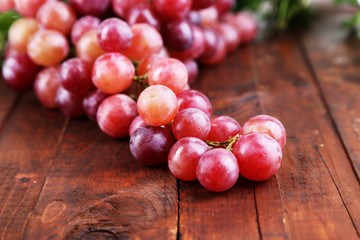 Ripe purple grapes on wooden table close-up