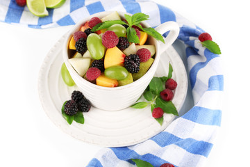 Fruit salad in cup near napkin isolated on white