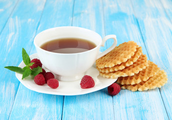 Cup of tea with cookies and raspberries on table close-up