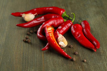 Red hot chili peppers  and garlic, on wooden background