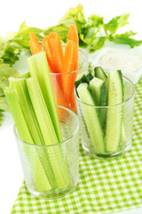 Fresh green celery with vegetables in glasses