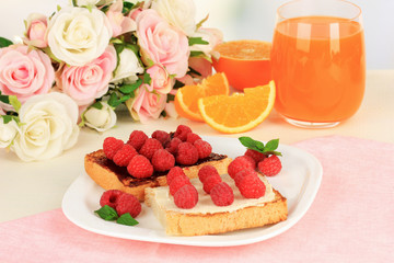 Delicious toast with raspberries on table on light background