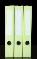 Green folders on wooden table, on grey background