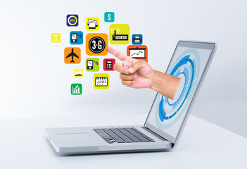 Hand from laptop screen touching social media icons