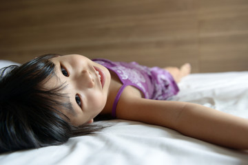 Obraz premium Little girl laying on bed