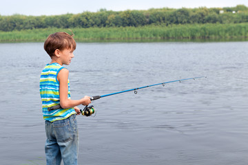 Boy fishing on river, summer