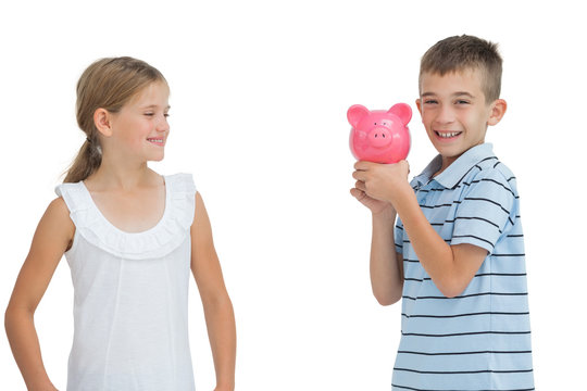 Smiling Young Boy Holding Piggy Bank