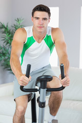 Obraz na płótnie Canvas Handsome man training on exercise bike