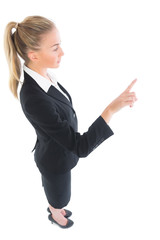 High angle profile view of young businesswoman pointing upwards