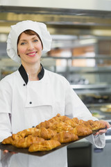 Young baker presenting croissants