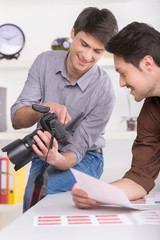 two men are choosing a photo from a shoot.