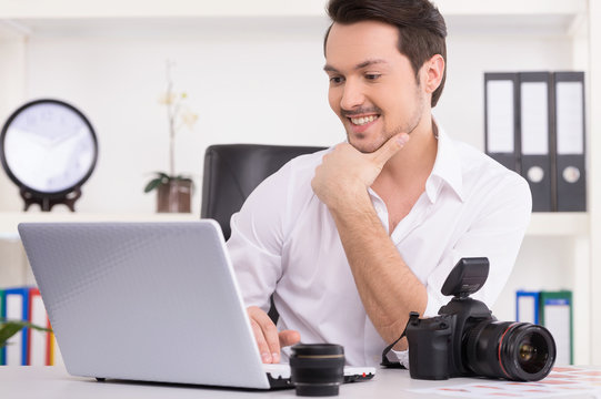 Man is looking at laptop with excitement.