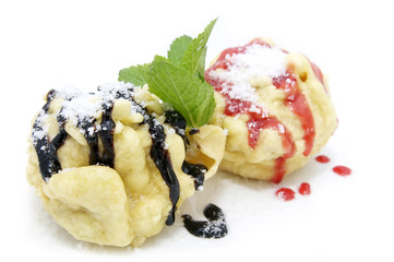 two eclairs decorated with mint sauce and a white background