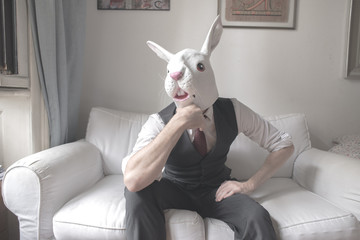 rabbit mask man sitting on sofa