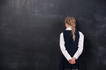 schoolgirl leaning her forehead against blackboard - Powered by Adobe