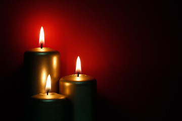 Three burning gold candles