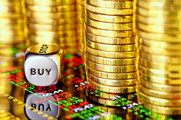 Golden coins, financial chart and dices cube with the word BUY.