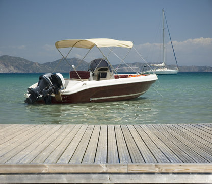 Fototapeta Motorboat moored by jetty