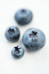 Macro shot of ripe blueberries over white wooden background