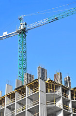 Fototapeta premium Crane and building construction site against blue sky