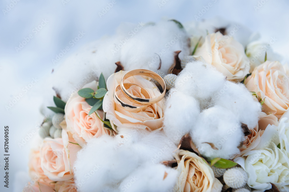 Wall mural wedding rings on a bouquet of roses and cotton