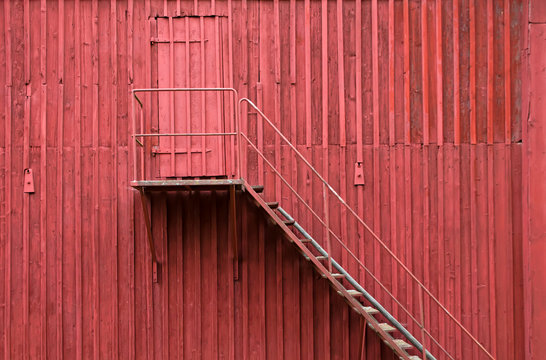 Staircase And Door On Red Wooden Wall