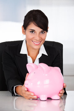 Young Happy Businesswoman Holding Pink Piggy Bank
