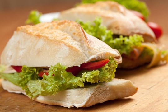 Tasty sandwiches with vegetables on a wooden table.