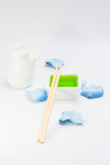 White bottle dish for sauce and green liquid with chopsticks