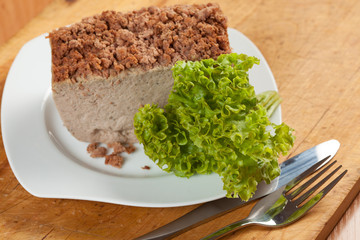 Venison pate on a plate decorated with salad.